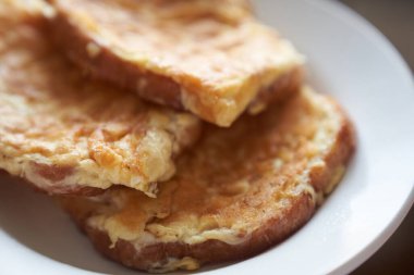 Beyaz tabakta nefis yumurtalı sandviçlerin yakın çekimi. Hızlı bir kahvaltı konsepti
