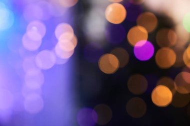 Bulanık bokeh 'in koyu mor arka planı ve sıcak renkli ışıklar. Kopyalamak için boşluk