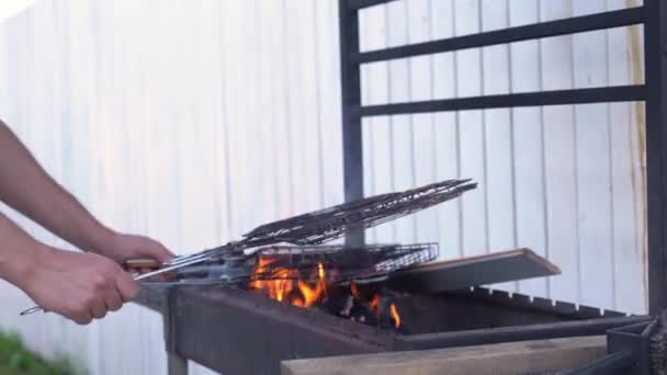 Męska ręka pali kwadratowy grill w ogniu. Piekę grilla na letniej werandzie. Koncepcja czyszczenia — Wideo stockowe