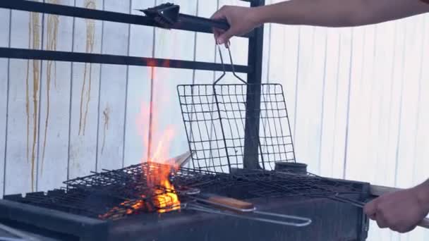 A mans hand cleans a square grate with a scrubber. Cleaning the grill on the summer veranda. Cleaning concept — Stock Video