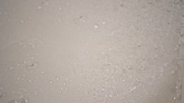 Bardakların üzerinde su damlaları olan beyaz bir zemin. Benekli ve su damlalı camlar..