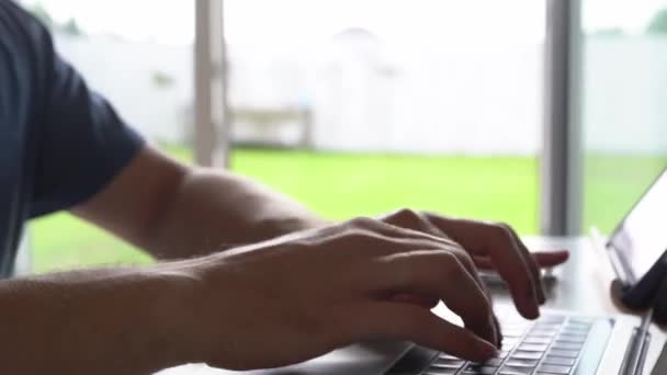Close-up van een mans handen typen op een toetsenbord, op zoek naar informatie. Een freelance copywriter werkt aan een project. Het concept van telewerken. — Stockvideo