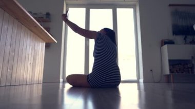 Mutlu bir kadın elini sallıyor ve akıllı telefon uygulaması kullanıyor. Uzaktan arkadaşlarla sanal bir online sohbetin tadını çıkarmak, mobil bir sohbetin içinde sanal bir görüşme..