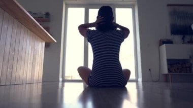 Esmer bir kadın pencerenin arkasında yoga derslerinden önce ısınmaya başlar. Tanımlanamayan hamile bir kadın lotus pozisyonunda yoga yapıyor. Sırtı kameraya dönük..