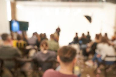 İş konferansının arka planı bulanık, sahnede bir grup insan, projenin sunumu, halka açık konuşma