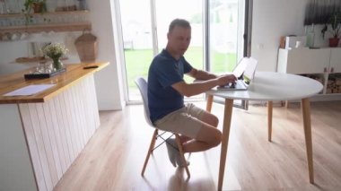 Yazan genç adam serbest çalışan biri. Modern bir dizüstü bilgisayarla evde otururken uzaktan çalışıyor..