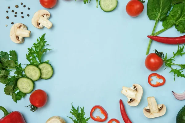 Mock up av grönsaker och örter på en ljus blå eller ljusblå bakgrund. Stockfoto