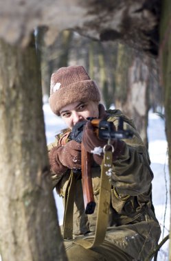 ormanda silahlı askeri üniformalı kadın