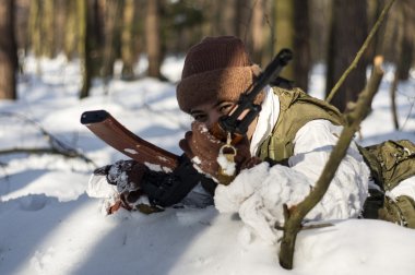 ormanda silahlı askeri üniformalı kadın