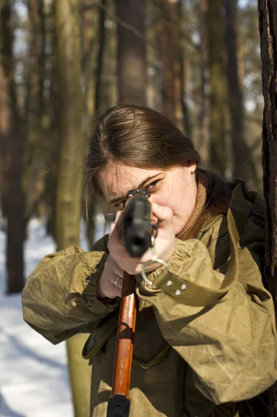 Kvinna i militär uniform i skogen med vapen — Stockfoto
