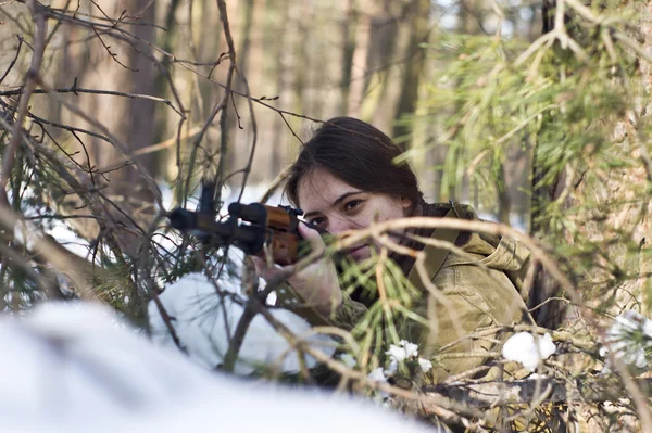 Женщина в военной форме в лесу с оружием — стоковое фото