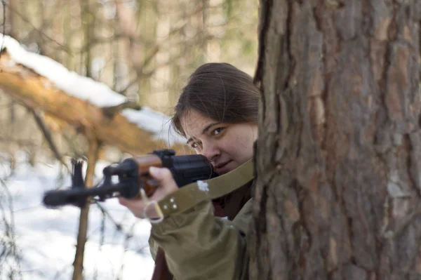 Žena ve vojenské uniformě v lese se zbraněmi — Stock fotografie