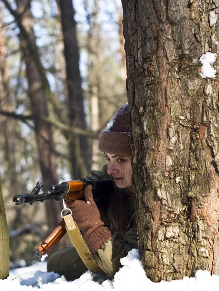 在树林里拿着枪的军人制服的女人 — 图库照片