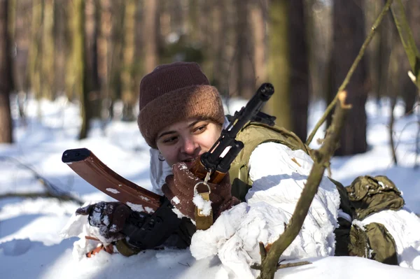 Женщина в военной форме в лесу с оружием — стоковое фото