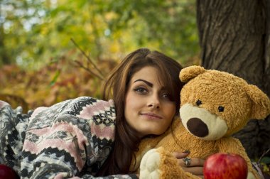 Kız ormanda oyuncak ayı ile sonbahar poz