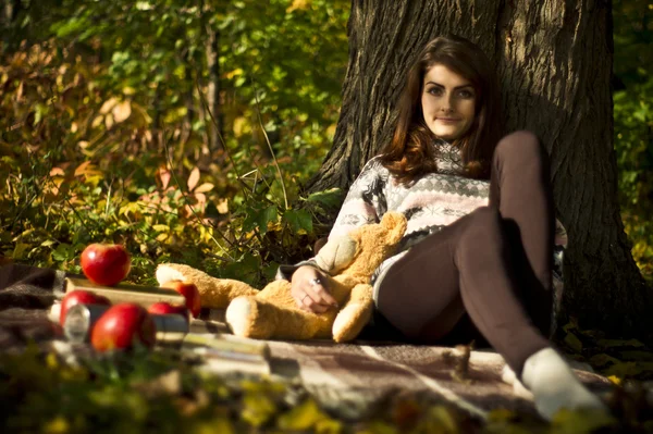 Mädchen posiert im Herbst mit Teddybär im Wald — Stockfoto