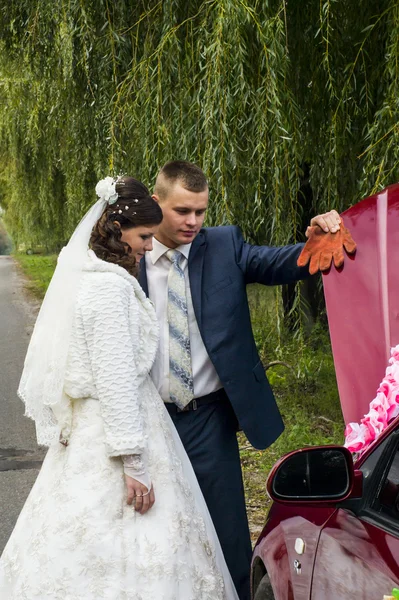 A menyasszony és a vőlegény megállította az autót a törött autó közelében — Stock Fotó