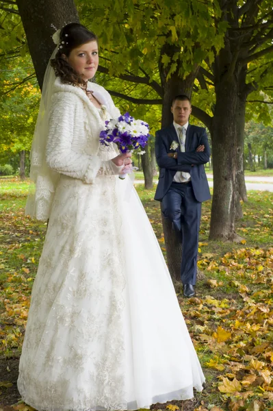 The groom and the bride on walk in autumn park — Stock Photo, Image