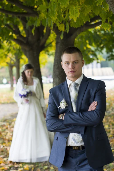 The groom and the bride on walk in autumn park — Stock Photo, Image