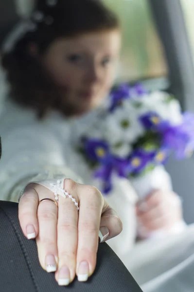 Ül egy autóban egy karikagyűrűt, a kezét a menyasszony — Stock Fotó
