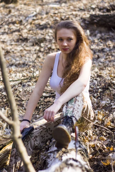 Beautiful young woman holding an automatic assault rifle — Stock Photo, Image