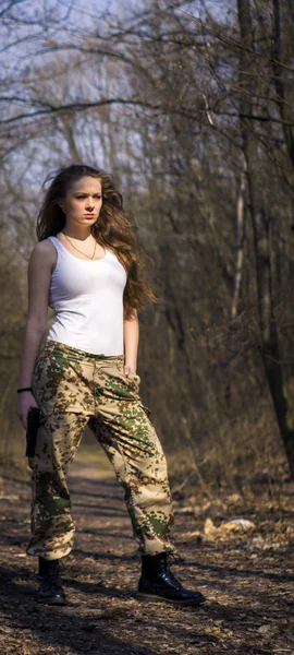 Beautiful young woman holding an automatic assault rifle — Stock Photo, Image