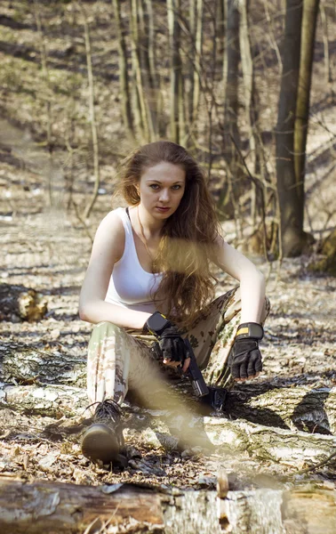 Beautiful young woman holding an automatic assault rifle — Stock Photo, Image