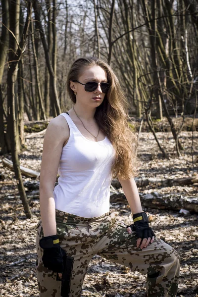 Beautiful young woman holding an automatic assault rifle — Stock Photo, Image