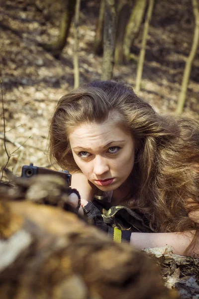 Beautiful young woman holding an automatic assault rifle — Stock Photo, Image