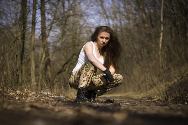 Beautiful young woman holding an automatic assault rifle — Stock Photo, Image