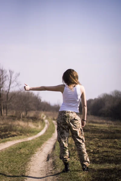 Beautiful young woman holding an automatic assault rifle — Stock Photo, Image