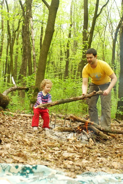 Papa petite fille aide à allumer un feu dans la forêt — Photo
