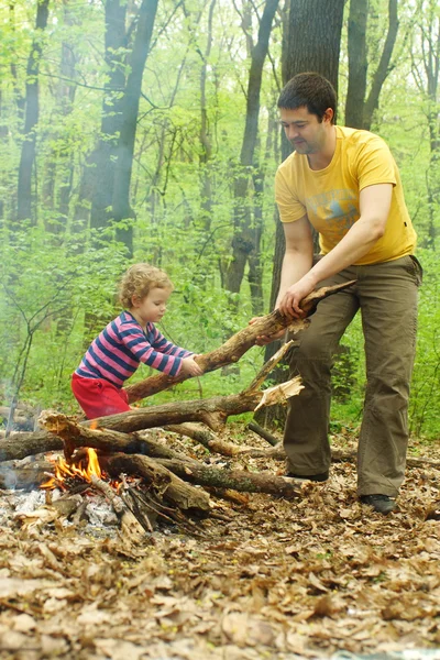 Papà bambina aiuta ad accendere un fuoco nella foresta — Foto Stock