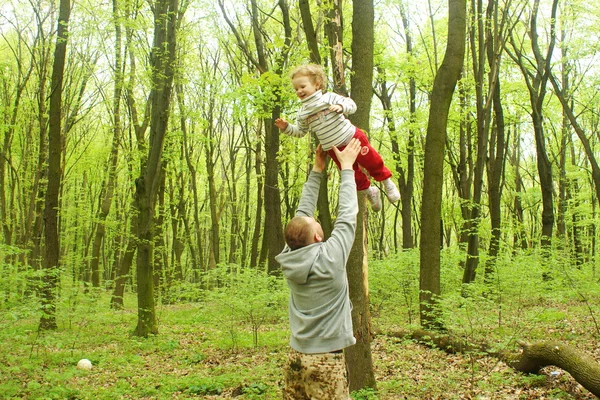 Man spelen met babymeisje gooien haar omhoog in het park — Stockfoto