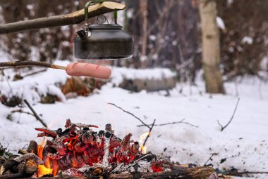 Çubuktaki sosisler ateşte kızardı. Kış Ormanı.