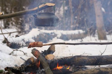 Çubuktaki sosisler ateşte kızardı. Kış Ormanı.