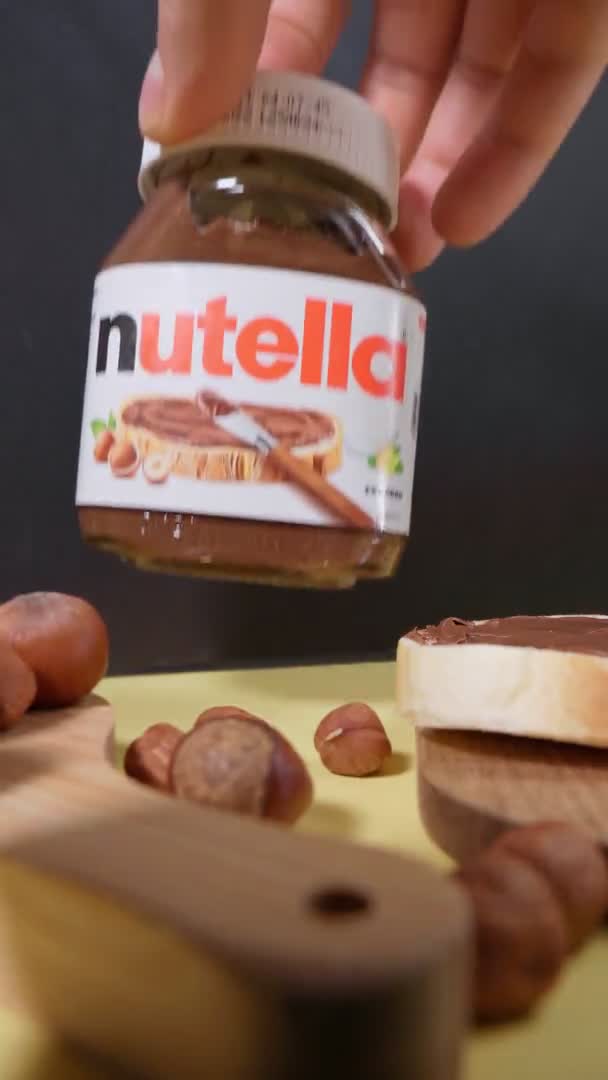 Tyumen, Rusko-15. října 2021: Nutella čokoládová pomazánka s lískovými oříšky. Ranní snídaně s těstovinami a ořechy. Svislé video — Stock video