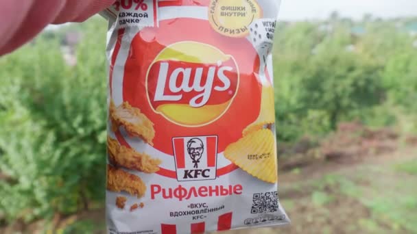 Volzhsky, Rusko-září 25, 2021: Chips Lays flétny kfc pikantní kuřecí křidélka. Selektivní zaměření — Stock video