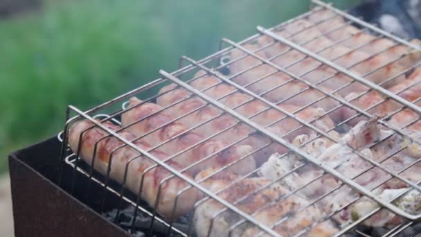 Grill z kiełbaskami gotowanie na grillu. Naturalne światło i selektywne skupienie. — Wideo stockowe