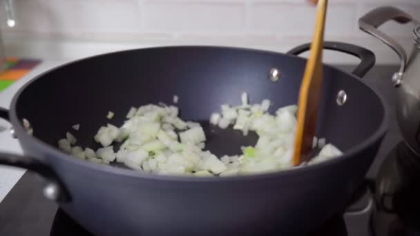 Ui in de koekenpan. Ik maak het eten klaar. Koken thuis concept. Selectieve focus. — Stockvideo