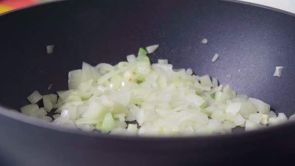 Cierre de cebolla salteada en la sartén. Preparando la cena. Cocinar en casa concepto. Enfoque selectivo. — Vídeos de Stock
