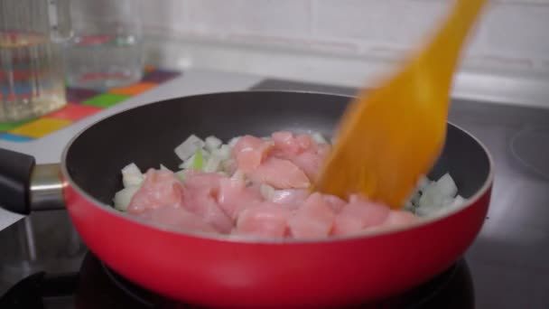 A csirkefalevelet egy serpenyőben sütik, hagymával a közelben. Főzés — Stock videók