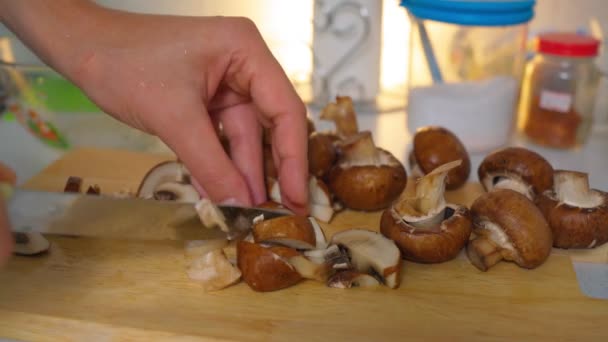 Funghi reali champignon tagliati a pezzi, primo piano su uno sfondo di legno. Un uomo cucina — Video Stock