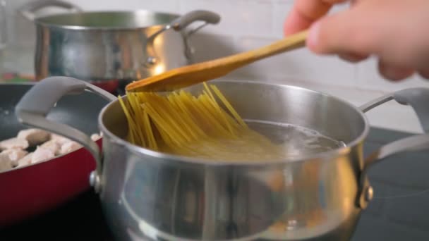 Μαγειρεύω μακαρόνια σε βραστό νερό στην κουζίνα. Επιλεκτική εστίαση — Αρχείο Βίντεο