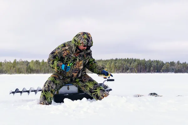 特別な服を着た漁師は湖で冬に魚を捕まえる 冬の野生生物の生存の概念 — ストック写真