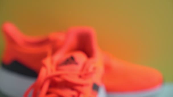 Tyumen, Russia-November 13, 2021: Adidas Löparskor, orange korall färg, Eq21 kör. Logotyp närbild — Stockvideo