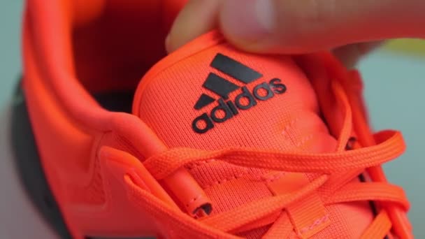 Тюмень, Россия-13 ноября 2021: Логотип Adidas на оранжевых кроссовках крупным планом. Селективный фокус — стоковое видео