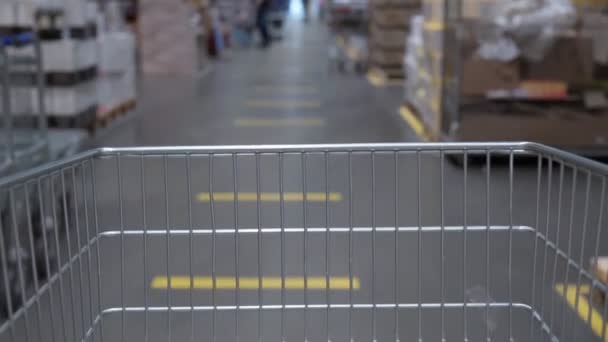 Customer is driving a grocery cart in a supermarket. Selective focus — Stockvideo