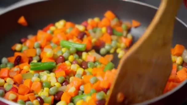 Cooking frying vegetables in a frying pan, corn, carrots, peas, beans — Stock Video