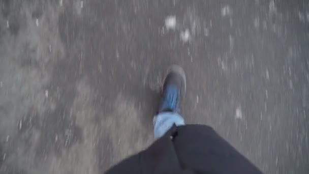 Siyah ayakkabılı ve kot pantolonlu bir adamın kışın asfaltta yürümesi. Pov videosu — Stok video